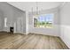 Sun-filled dining room with wood floors, elegant chandelier, wainscoting, fireplace and expansive windows at 5377 River Buck Rd, Spring Hope, NC 27882
