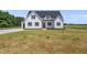 Two-story home with white siding, black shutters, and a bright red front door at 5377 River Buck Rd, Spring Hope, NC 27882