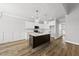 Bright kitchen with white cabinets, stainless appliances, dark island, and seamless flow into dining at 5377 River Buck Rd, Spring Hope, NC 27882