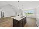 Modern kitchen island featuring a stainless steel sink and dark wood cabinetry, enhancing the open layout at 5377 River Buck Rd, Spring Hope, NC 27882