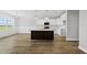 Modern kitchen with a dark kitchen island, white cabinets, and hardwood floors at 5377 River Buck Rd, Spring Hope, NC 27882