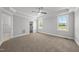 Spacious bedroom featuring tray ceilings, ceiling fan, plush carpeting and large windows with lots of natural light at 5377 River Buck Rd, Spring Hope, NC 27882
