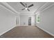 Large bedroom featuring a ceiling fan, tray ceiling, plush carpet and views of the outdoor landscape at 5377 River Buck Rd, Spring Hope, NC 27882
