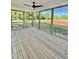 Screened in patio with natural wood flooring and fan overlooking a field at 5377 River Buck Rd, Spring Hope, NC 27882