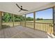 This screened porch features wood flooring, a ceiling fan, and a view of the property at 5377 River Buck Rd, Spring Hope, NC 27882