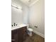 This half bathroom features a floating vanity, dark hardware, and wood flooring at 5820 Shawood Dr, Raleigh, NC 27609