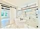 This bathroom features a soaking tub, glass shower, black hardware, and marble tile at 5820 Shawood Dr, Raleigh, NC 27609