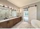 Modern bathroom featuring marble floors, double vanity, and glass shower with white door at 5820 Shawood Dr, Raleigh, NC 27609