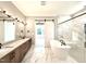 Modern bathroom with marble floors, a soaking tub, double vanities, and a glass-enclosed shower at 5820 Shawood Dr, Raleigh, NC 27609