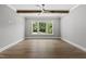 Bright bedroom with hardwood flooring, ceiling fan, and a large window overlooking greenery at 5820 Shawood Dr, Raleigh, NC 27609