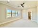 Bright bedroom with a ceiling fan, neutral carpet, white trim, and an attached bathroom at 5820 Shawood Dr, Raleigh, NC 27609