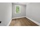 Cozy bedroom with hardwood floors and a window offering a view of trees and sky at 5820 Shawood Dr, Raleigh, NC 27609