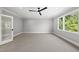 Neutral bedroom featuring a ceiling fan and large window at 5820 Shawood Dr, Raleigh, NC 27609