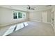 Spacious bedroom features a ceiling fan, neutral carpet, white trim, and large windows at 5820 Shawood Dr, Raleigh, NC 27609