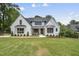 A beautiful, newly constructed two-story home with white painted brick and a well-manicured lawn at 5820 Shawood Dr, Raleigh, NC 27609