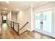 Upstairs hallway with hardwood floors and double doors leading to a bright room at 5820 Shawood Dr, Raleigh, NC 27609