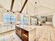 Open kitchen with island and view into living room featuring fireplace and built-in cabinets at 5820 Shawood Dr, Raleigh, NC 27609