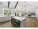 Open concept kitchen with island, quartz countertops, and stainless steel microwave features hardwood flooring throughout at 5820 Shawood Dr, Raleigh, NC 27609