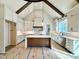 Bright kitchen featuring white cabinets, a center island, stainless steel appliances, and vaulted ceilings at 5820 Shawood Dr, Raleigh, NC 27609