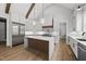 Open kitchen with a center island, stainless steel appliances, wood accents, and hardwood floors at 5820 Shawood Dr, Raleigh, NC 27609