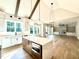 Sun-drenched kitchen with large island, views of the fireplace and outdoor scenery at 5820 Shawood Dr, Raleigh, NC 27609