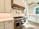 Gourmet kitchen with a professional grade stove, hood, and white cabinets at 5820 Shawood Dr, Raleigh, NC 27609