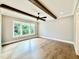 Living room highlighting hardwood floors, dark wood beams, and large windows at 5820 Shawood Dr, Raleigh, NC 27609