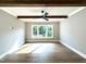 Living room with hardwood floors, dark wood beam accents, and natural light from large windows at 5820 Shawood Dr, Raleigh, NC 27609