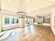 Open living room with a fireplace, hardwood floors, large windows, and modern lighting at 5820 Shawood Dr, Raleigh, NC 27609