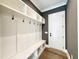Mudroom with built-in bench, cubbies, hooks, and wood flooring at 5820 Shawood Dr, Raleigh, NC 27609