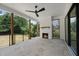 Covered outdoor living space with a stone floor, fireplace, and ceiling fan for comfort at 5820 Shawood Dr, Raleigh, NC 27609
