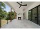Covered outdoor living space with a stone floor, fireplace, and ceiling fan for relaxation at 5820 Shawood Dr, Raleigh, NC 27609