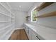 Walk-in pantry with custom built-in shelves, countertops, storage cabinets, and natural light at 5820 Shawood Dr, Raleigh, NC 27609