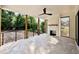 Spacious outdoor patio with fireplace, ceiling fan, stone floors, and backyard view at 5820 Shawood Dr, Raleigh, NC 27609