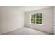 Spacious bedroom with large window and plush carpeting at 8619 Brixton Shay Dr, Raleigh, NC 27616