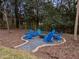 Secluded backyard seating area featuring blue Adirondack chairs around a stone fire pit at 1000 Norris St, Raleigh, NC 27604
