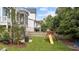 Lush backyard featuring a playset, garden bed, and a patio beneath a raised porch at 1000 Norris St, Raleigh, NC 27604
