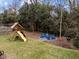 A spacious backyard featuring a playset and an outdoor seating area with Adirondack chairs at 1000 Norris St, Raleigh, NC 27604