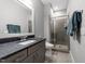 Modern bathroom featuring a glass-enclosed shower and sleek vanity with stone countertop at 1000 Norris St, Raleigh, NC 27604