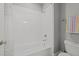 Clean bathroom with a white-tiled tub and shower combination, a light grey wall, and simple fixtures at 1000 Norris St, Raleigh, NC 27604