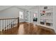 Hallway with hardwood floors, built in shelves, and a view into the main bedroom at 1000 Norris St, Raleigh, NC 27604