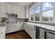 Bright kitchen with white cabinets, farmhouse sink, stainless steel appliances, and hardwood floors at 1000 Norris St, Raleigh, NC 27604