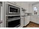 Stainless steel appliances built into white cabinets above and below the cooktop at 1000 Norris St, Raleigh, NC 27604