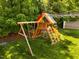 Backyard featuring a colorful wooden playground set on lush green grass at 1000 Norris St, Raleigh, NC 27604