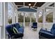 Inviting screened-in porch with comfortable seating, tile floors, and views of the surrounding trees at 1000 Norris St, Raleigh, NC 27604