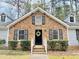 Charming brick home featuring black shutters, dormer windows, and a welcoming front door with a wreath at 103 Cimmaron Ct, Cary, NC 27511