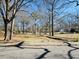 Neighborhood street scene with mature trees lining the road and a view of houses in the distance at 103 Cimmaron Ct, Cary, NC 27511