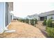 Backyard with a black metal fence, green shrubs, and a partial view of the rear exterior at 125 Canary Ct. Ct, Raleigh, NC 27610