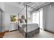 Bright bedroom with canopy bed, hardwood floors, and city view at 1300 St Marys St # 404, Raleigh, NC 27605