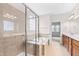 Bathroom featuring a glass-enclosed shower, soaking tub, and a double sink vanity at 1400 Basley St, Wake Forest, NC 27587